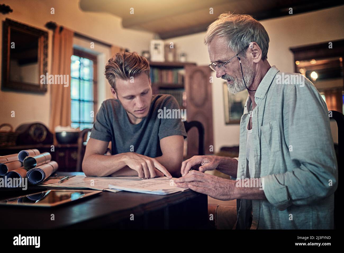 These great minds think alike. Shot of a father and his son working on a design for their family business at home. Stock Photo