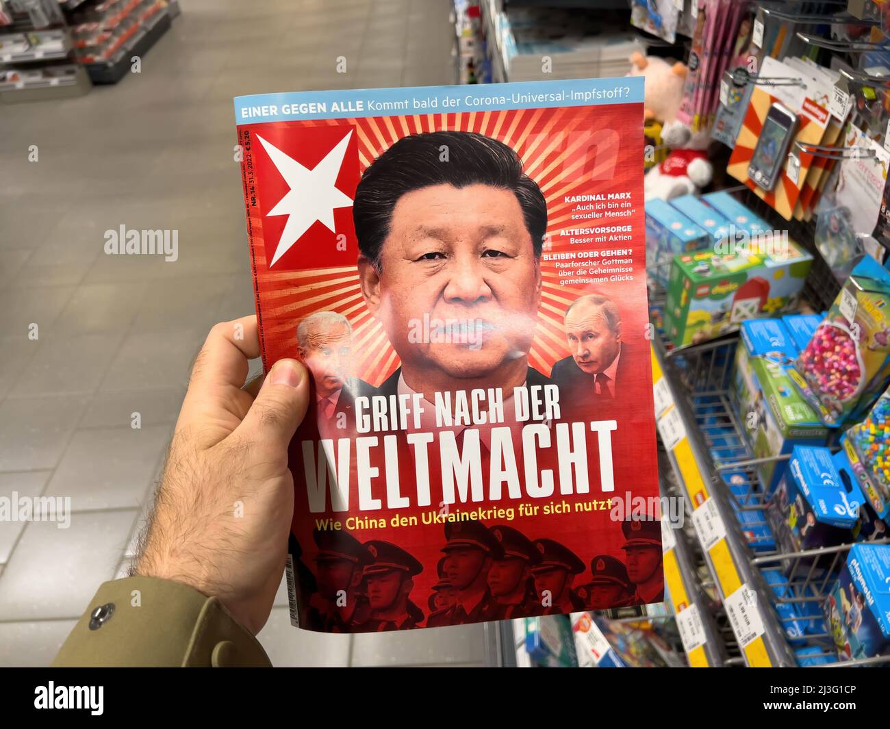 Frankfurt, Germany - Ap 2, 2022: POV male hand holding in newspaper kiosk latest edition of the German Stern magazine with the Xi Jinping General Secretary of the Chinese Communist Party, Vladimir Putin Russian Federation president and Joe Biden USA President Stock Photo
