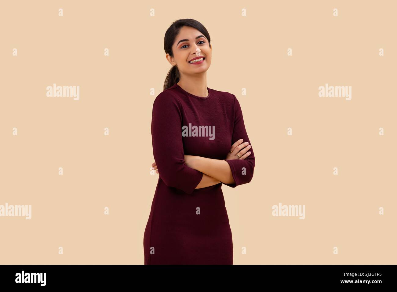 Portrait of a happy young woman posing with arms crossed Stock Photo ...