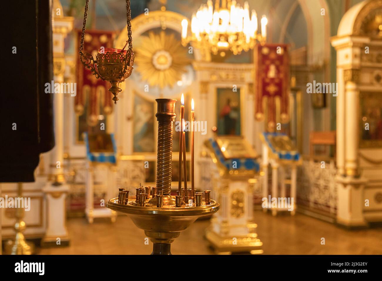 Orthodox Church. Christianity. Festive interior decoration with burning candles and icon in traditional Orthodox Church on Easter Eve or Christmas. Religion faith pray symbol Stock Photo