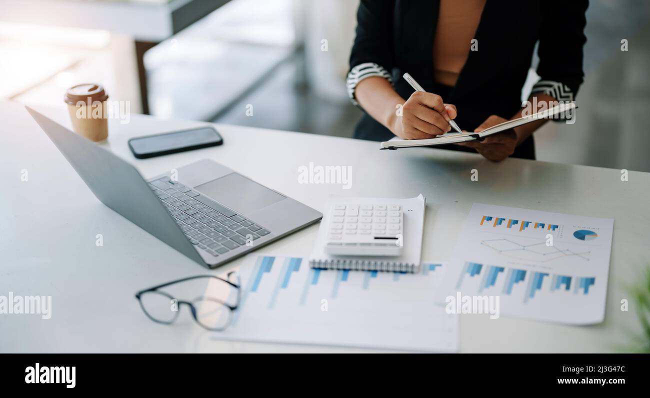 Closes up accountant asian woman hand is writing on notepad with pen in office. business accounting concept. Stock Photo