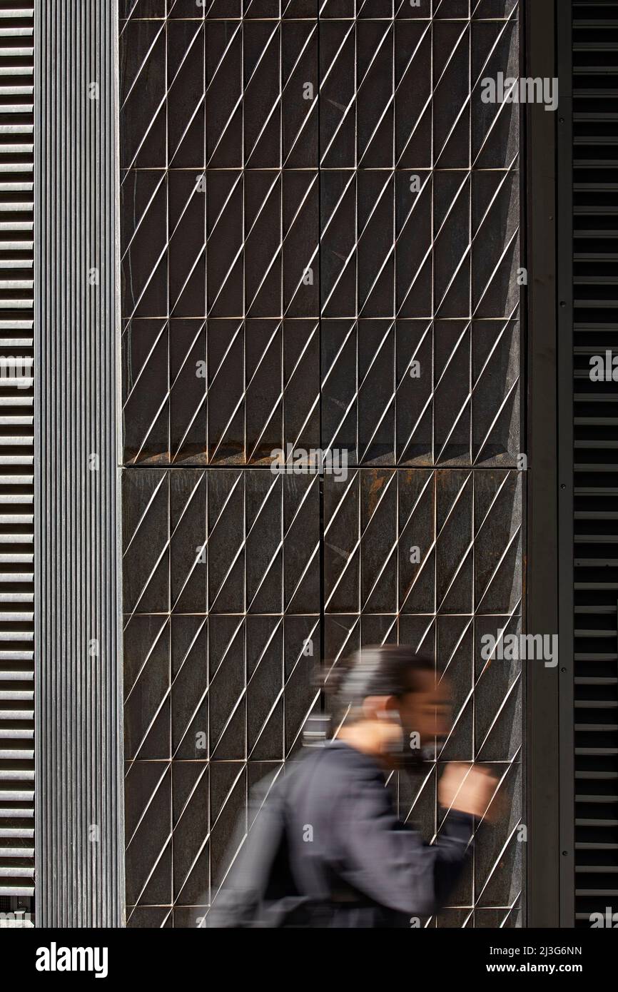 Passages: moving figure in front of cast iron facade. 66 Shoe Lane, London, United Kingdom. Architect: Stiff + Trevillion Architects, 2020. Stock Photo