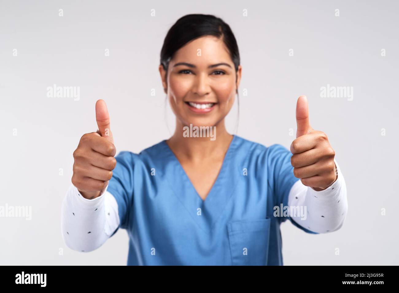 I live where soul meets body. Portrait of a young doctor showing a thumbs up sign against a white background. Stock Photo