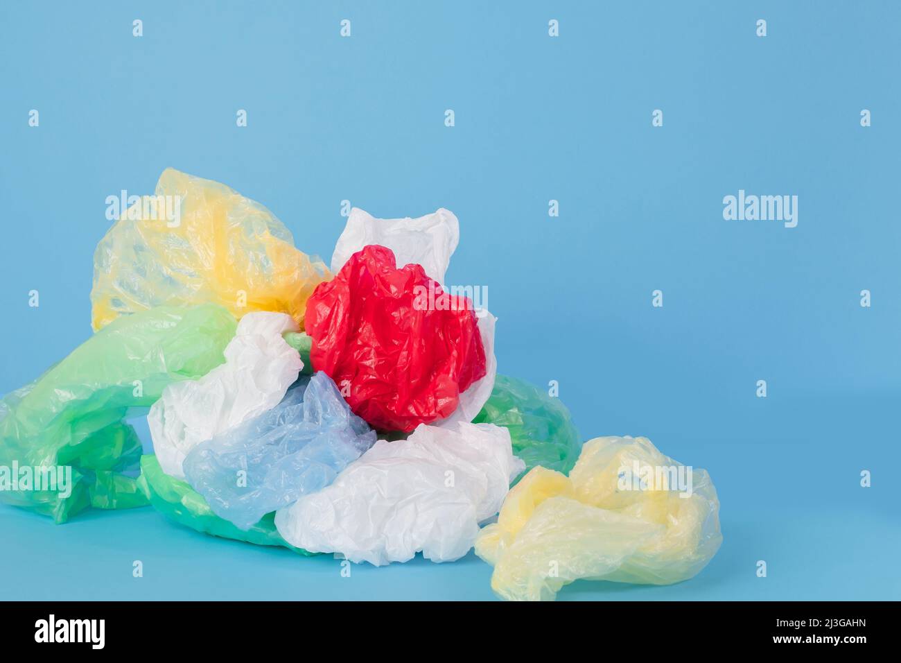 Plastic bags and plastic wraps of different colors on a blue background