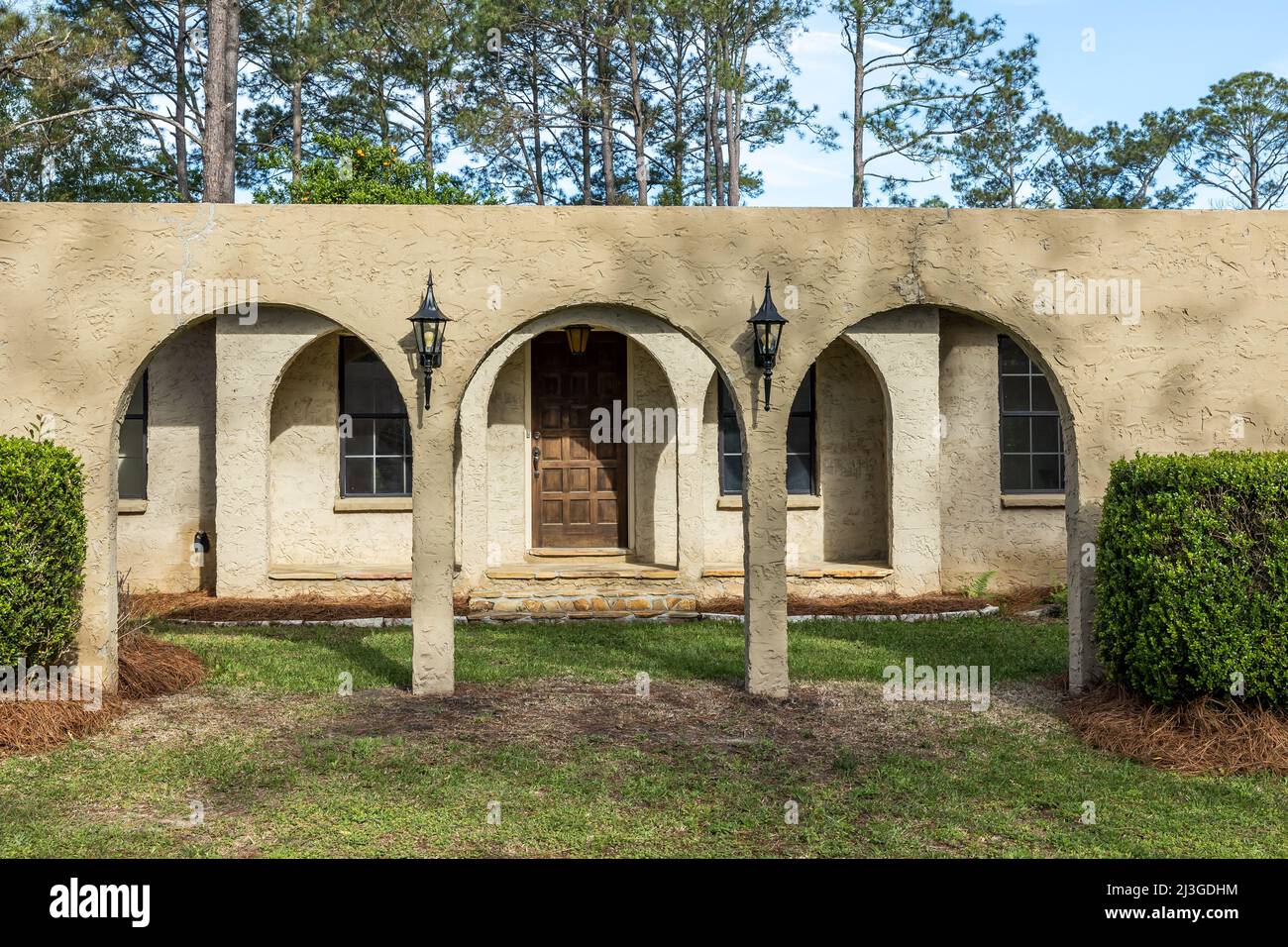 The front view of a brown ranch style spanish style villa stucco cinder