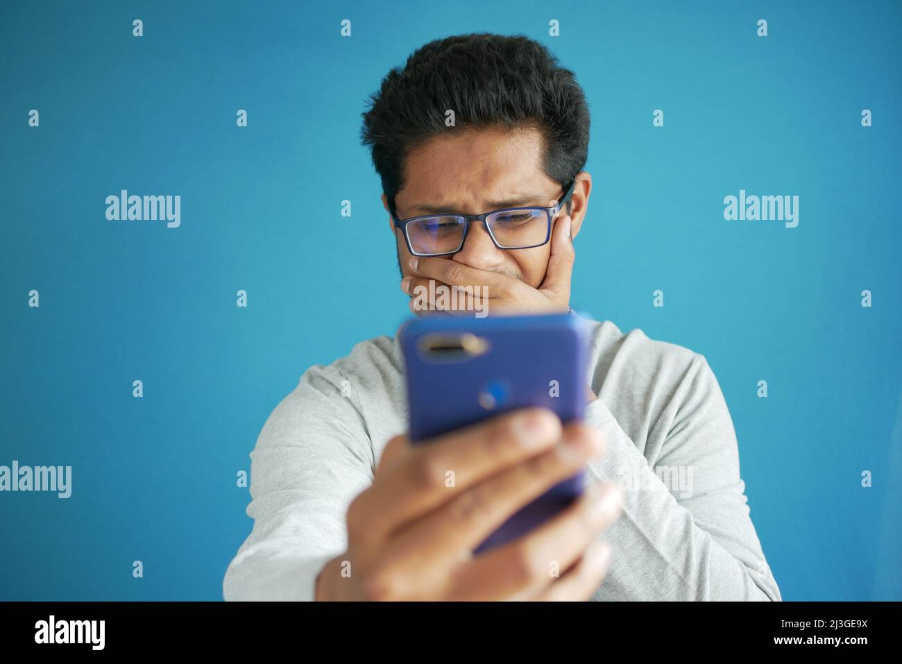 sad young man using smart phone indoor Stock Photo