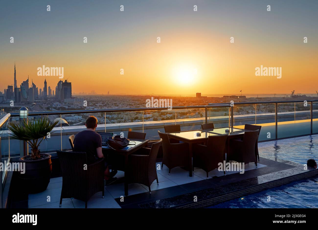 Dubai. UAE. Smartworking at sunset from a rooftop hotel pool Stock Photo