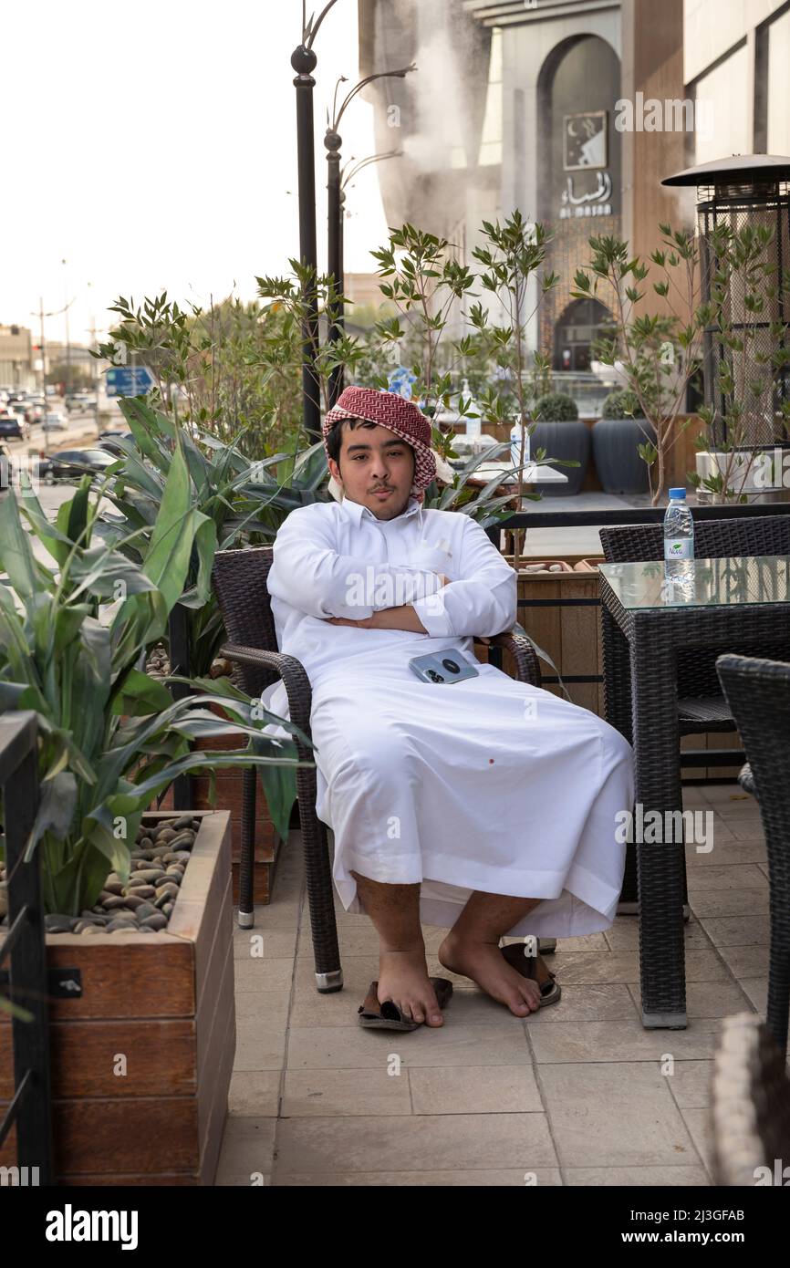 Riyadh, Saudi Arabia, 1st April 2022: saudi man in a coffee shop and street picture of Riyadh, Olaya street Stock Photo