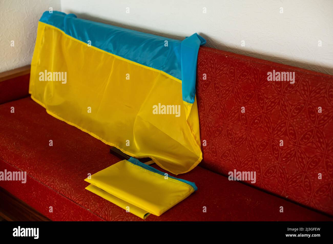 A folded Ukrainian flag lying on the couch Stock Photo