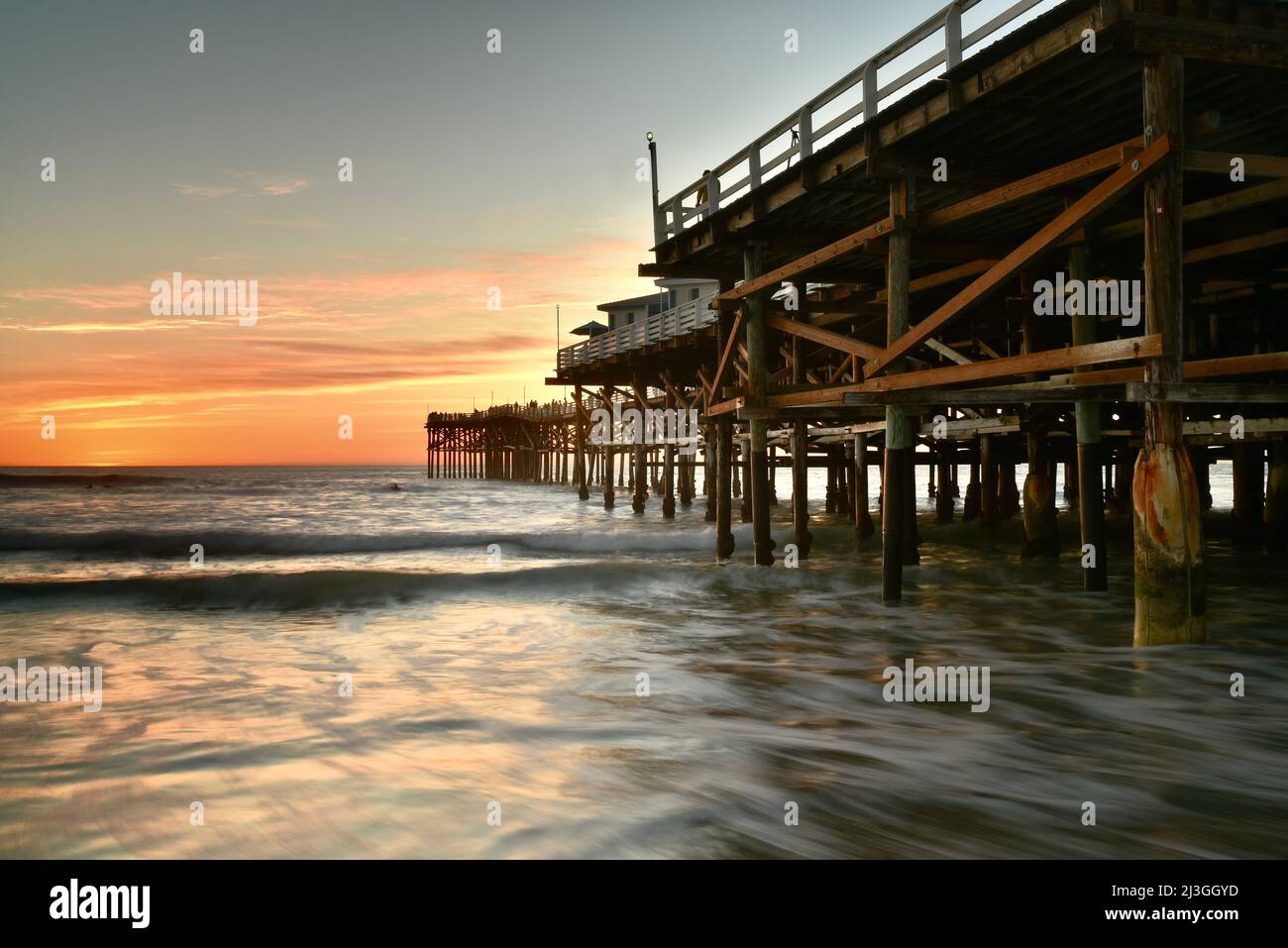 Dramatic sunset with surf waves breaking at Crystal Pier and Crystal