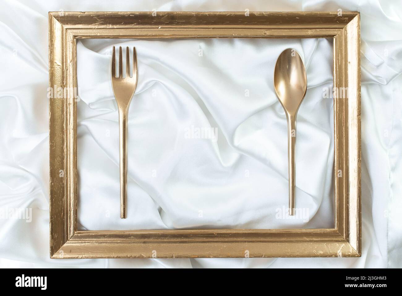 restaurant poster, menu, business card luxury mockup. Creative concept of a dinner setting with golden frame, spoon and fork Stock Photo