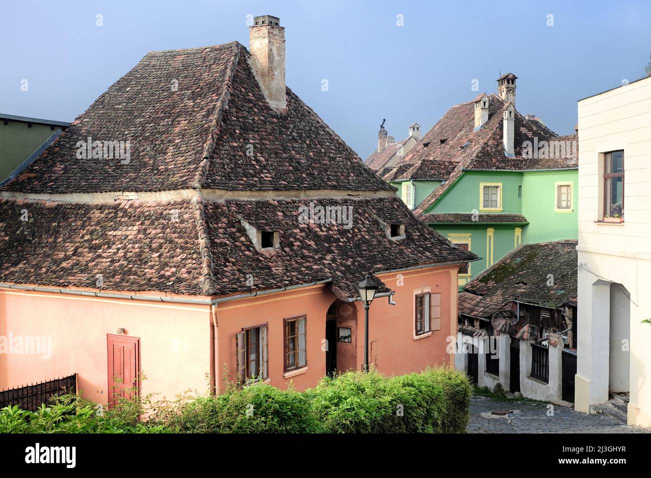 Sighisoara street and tiled roofs of colorful traditional houses in Old Town, Romania Stock Photo