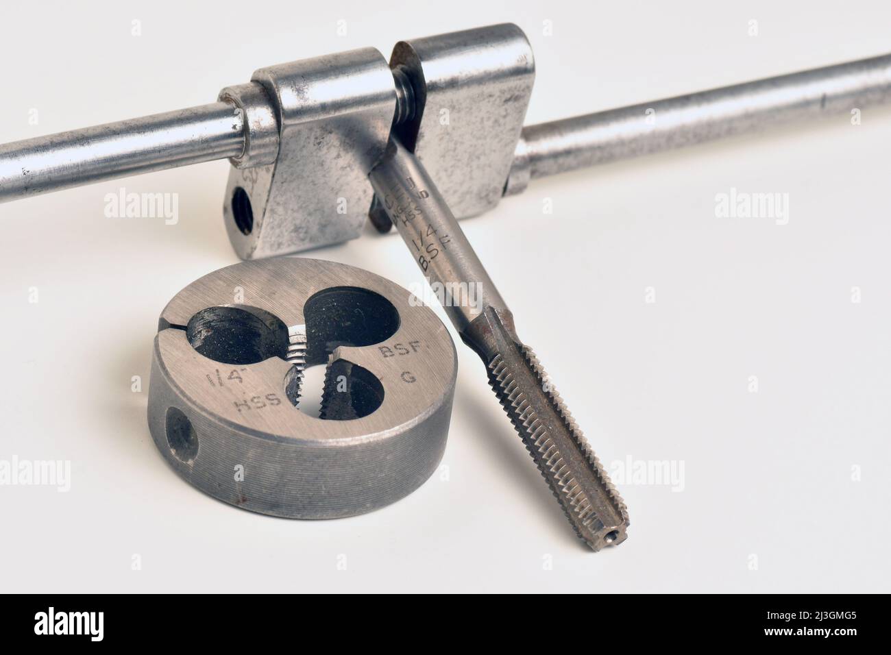 A metal thread cutting tap, held in an apprentice hand made Tap Holder