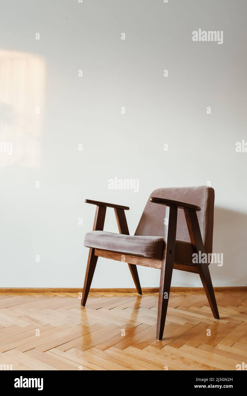 Grey vintage armchair on wooden parquet floor Stock Photo - Alamy