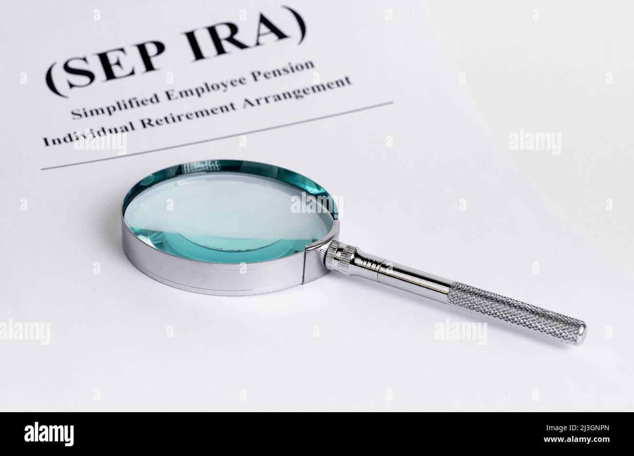 Paper with SEP IRA words and magnifying glass. Simplified Employee Pension Individual Retirement Arrangement. Analysis and planning of contributions. Business and finance concept. High quality photo Stock Photo
