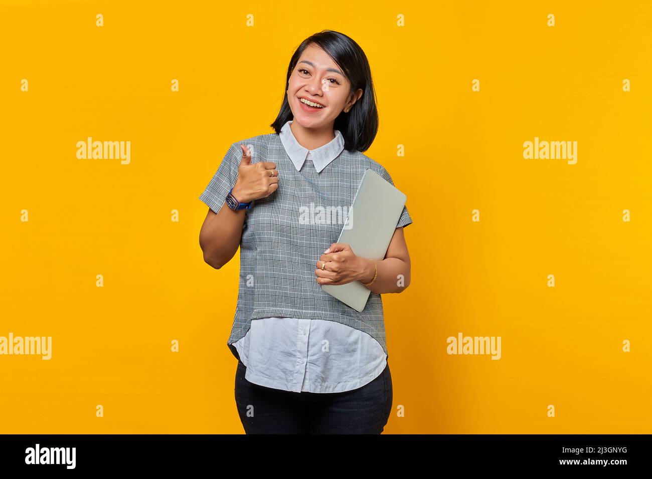 Beautiful Asian woman holding laptop smiling and showing thumbs up sign ...
