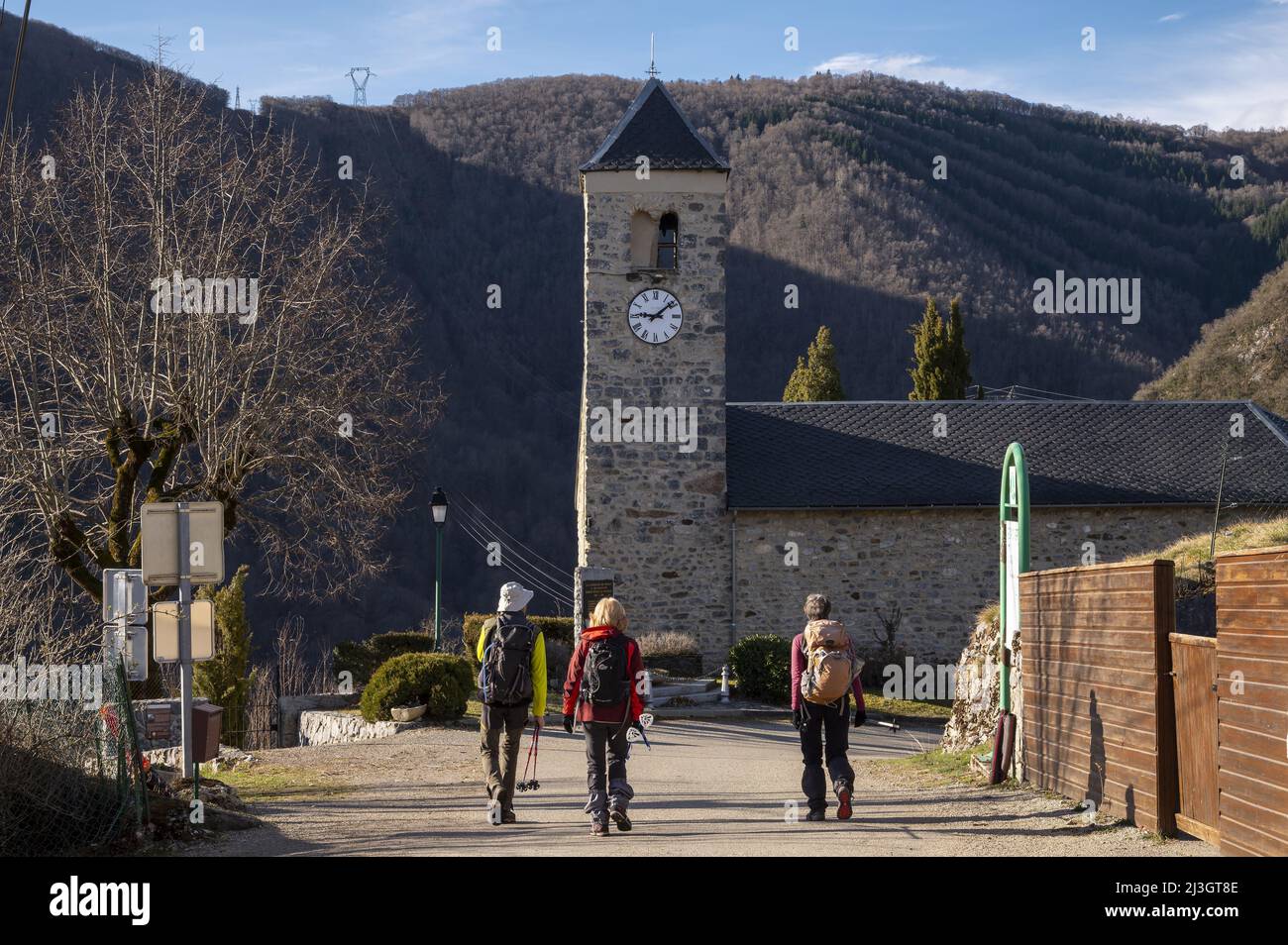 France, Ariege, Pyrenees massif, Tarascon sur Ariege, the church of Genat, departure of hikes and 3 hikers Stock Photo