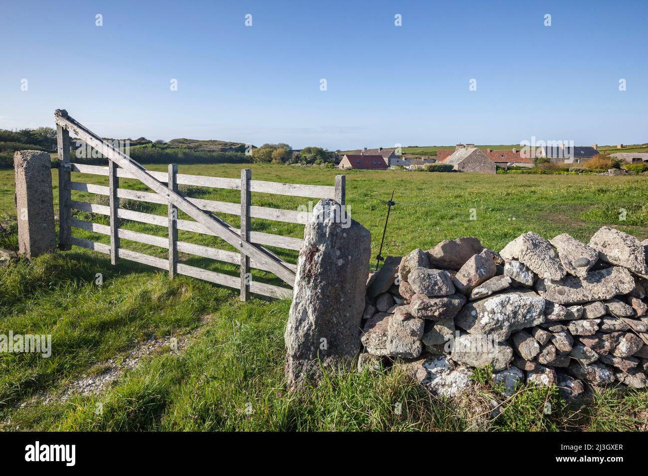 France, Manche, Cotentin, Cape Hague, Jobourg, bay of Ecalgrain, wooden gate, low stone wall and traditionnal stone houses in the background Stock Photo