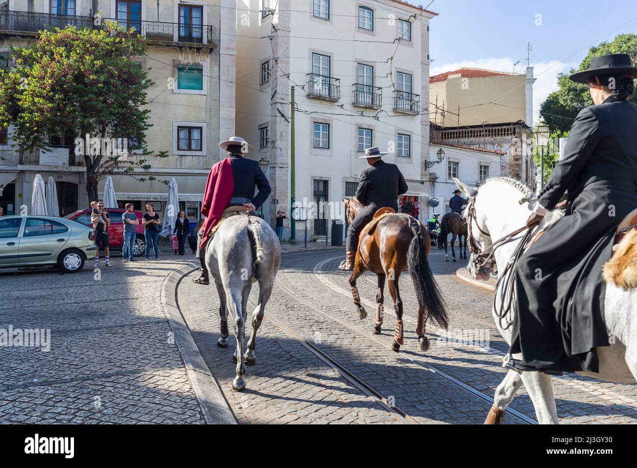 Portugal, Lisbon, Alfama district, rider riding down the street during ...