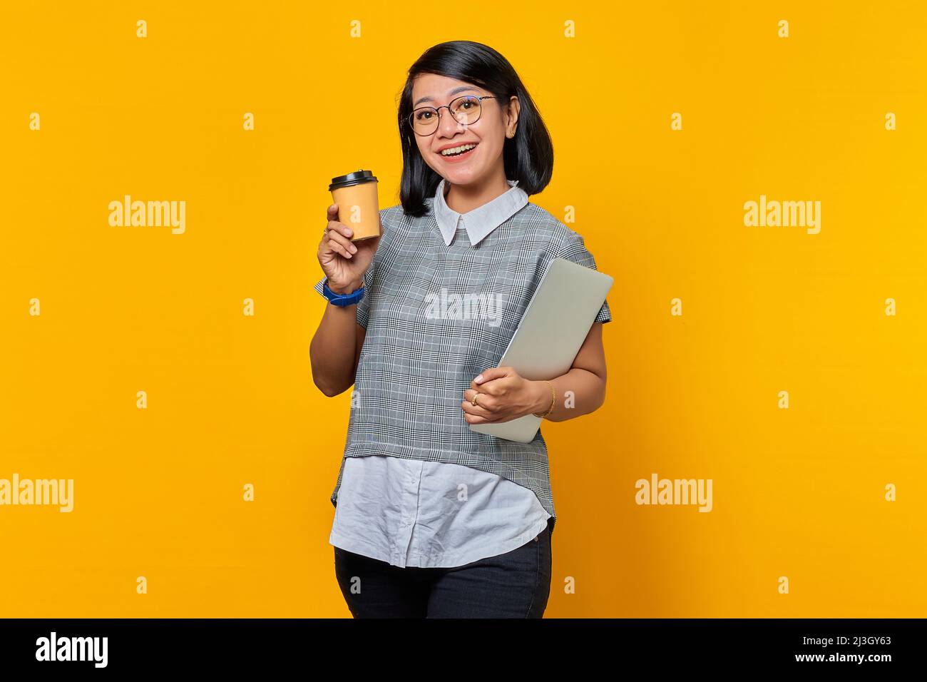 Portrait of Cheerful Asian woman wearing glasses holding laptop and ...