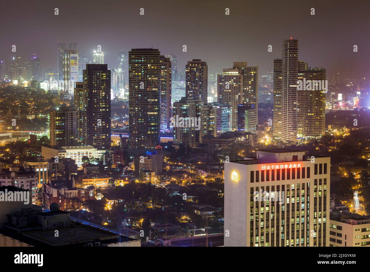 Philippines, Metro Manila, Makati District, elevated view of skyscrapers and Metrobank building at night, view from City Bank tower Stock Photo