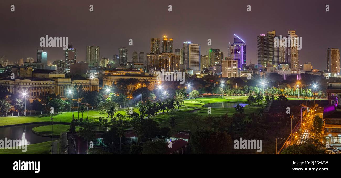 Philippines, Metro Manila, Intramuros, view from the Bayleaf Hotel, very high resolution elevated panoramic view of Museum of Fine Arts buildings, in front of Club Intramuros Golf Course, illuminated at night Stock Photo