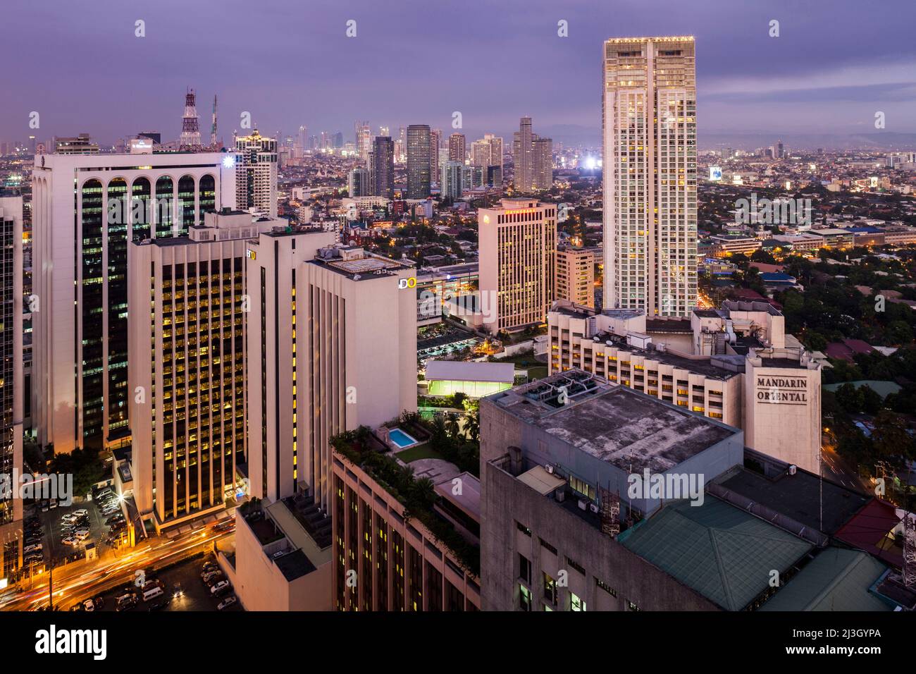 Philippines, Metro Manila, Makati District, elevated view of skyscrapers and Mandarin Oriental Hotel at dusk Stock Photo