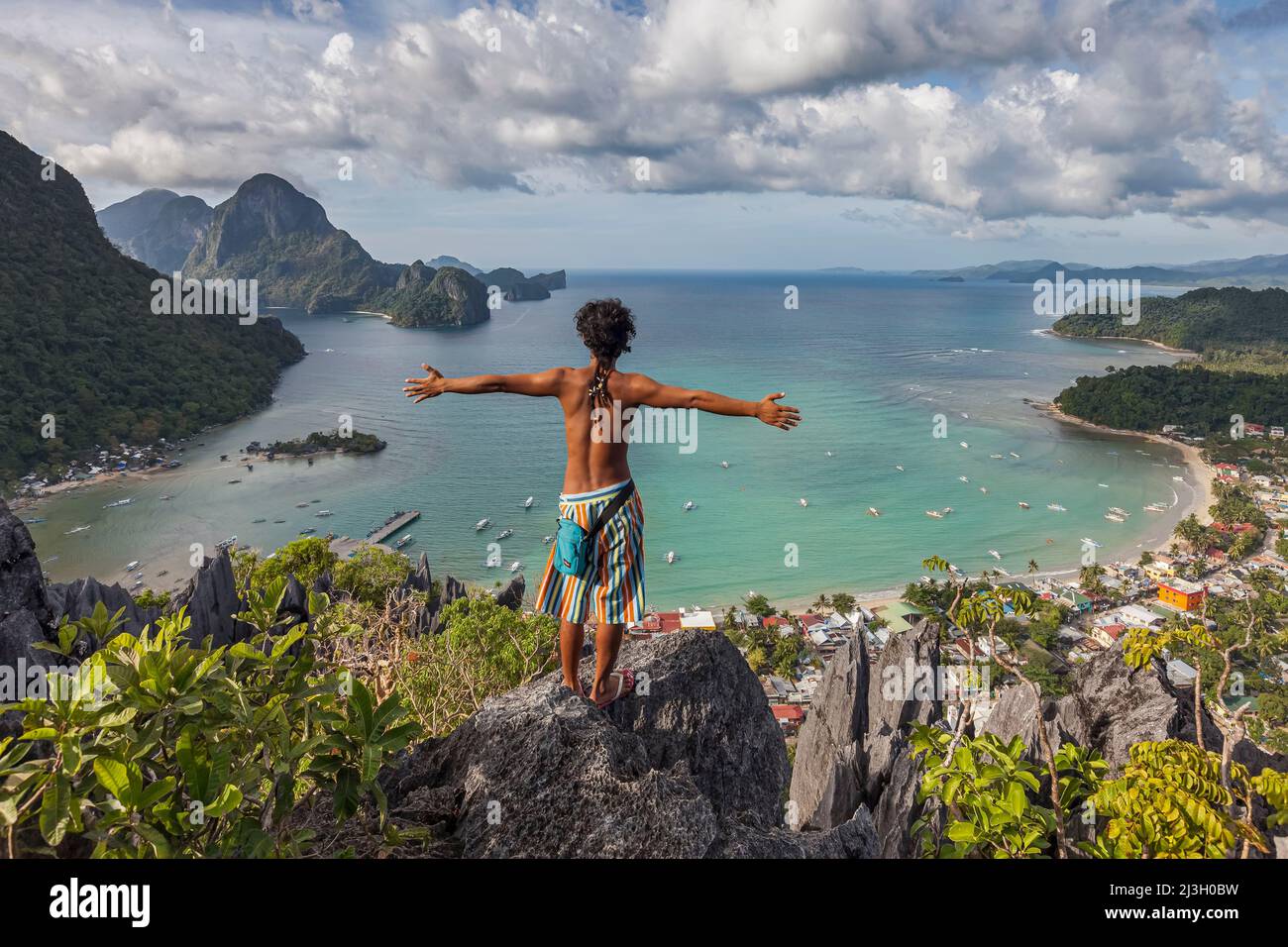 Philippines, Palawan, El Nido, a young Filipino man admires the whole bay of El Nido, from the top of Taraw cliff Stock Photo