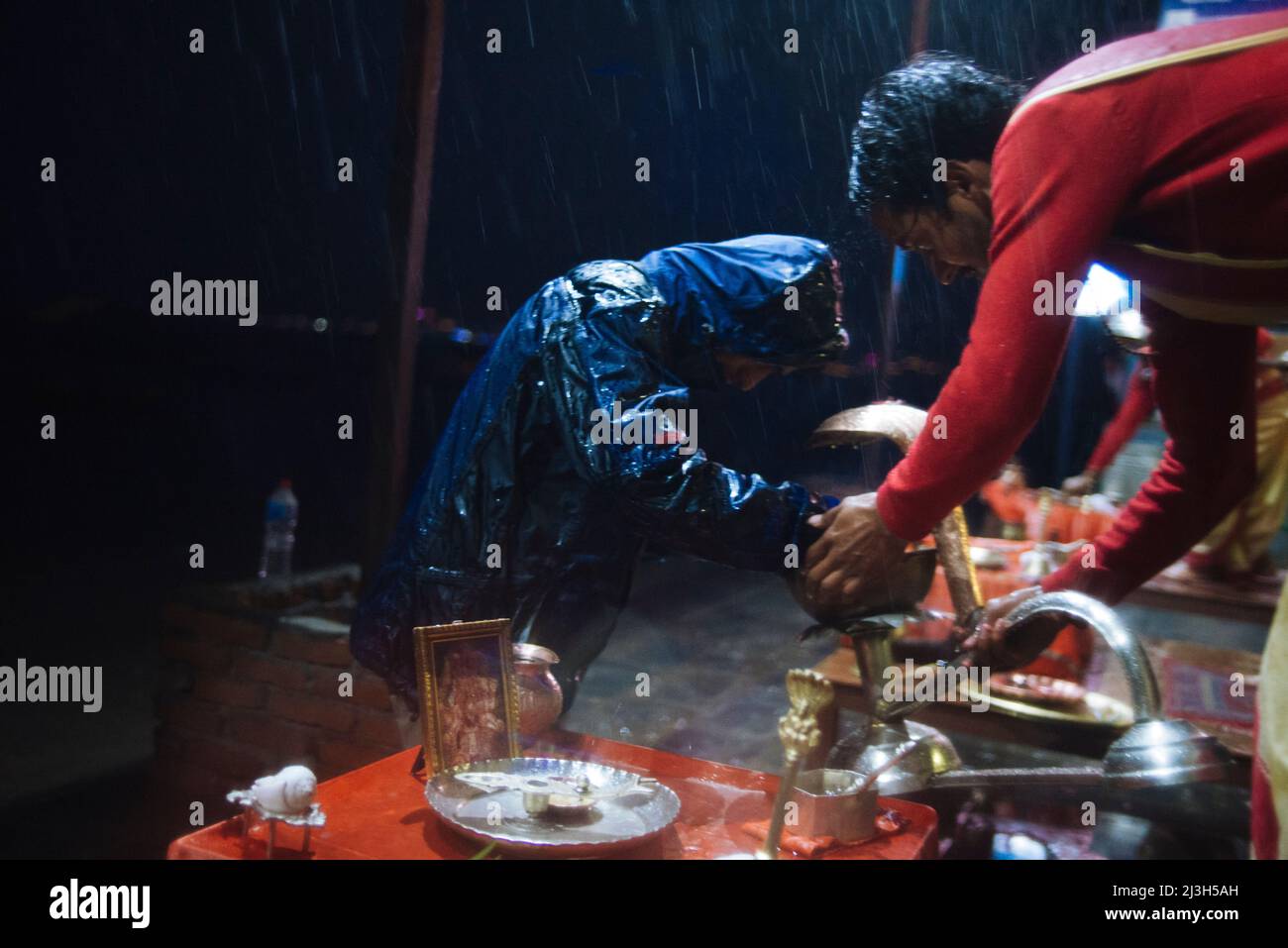 Nepalese Hindu priests perform evening Aarti ceremony during heavy rain ...