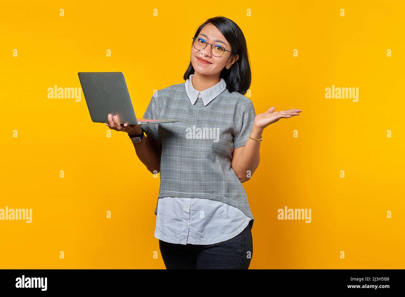 Portrait of Smiling Asian woman wearing glasses holding laptop and ...