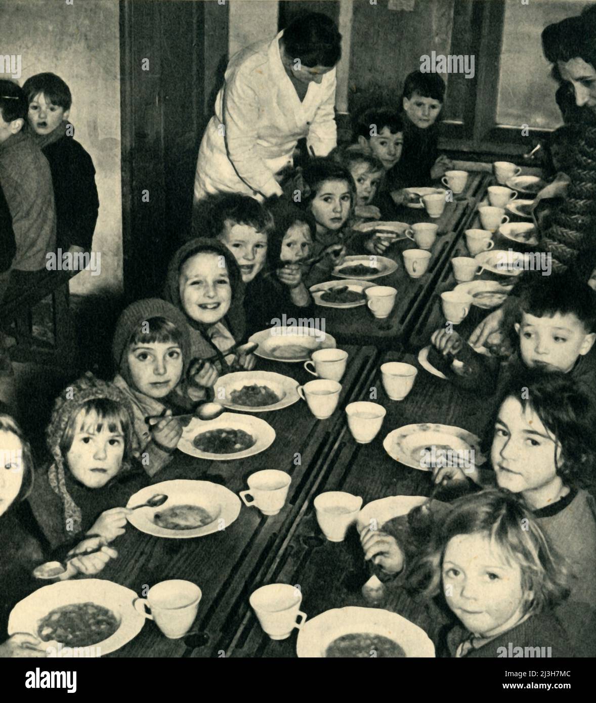 'School Dinner for Evacuated Children', 1943. Scene from the Second World War: British evacuees are fed. From &quot;Women's Institutes', by Cicely McCall. [Collins, London, 1943] Stock Photo