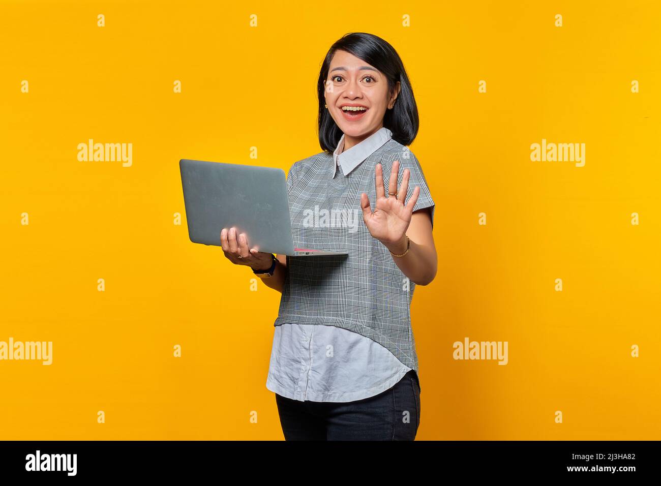Portrait of beautiful confident young Asian woman holding laptop and ...