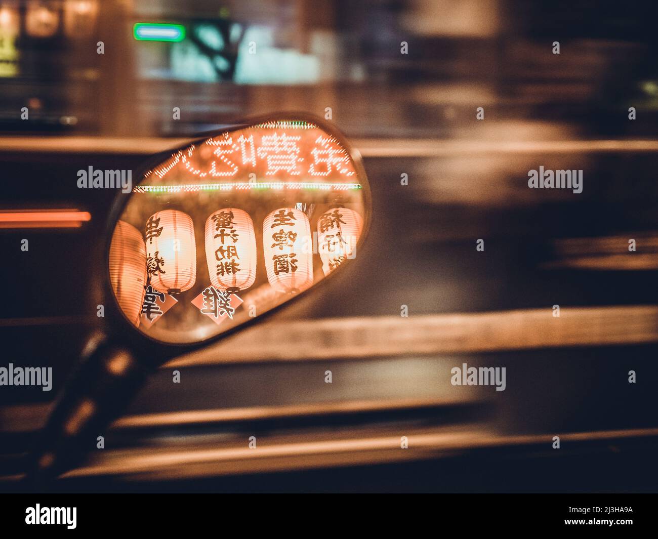 Reflections of lanterns and signs in a side-view mirror, with light trails in background, Taipei Stock Photo