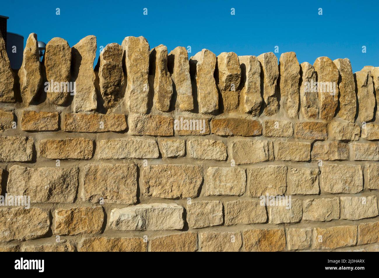 Newly-built stone wall against blue sky, Oxford, UK Stock Photo