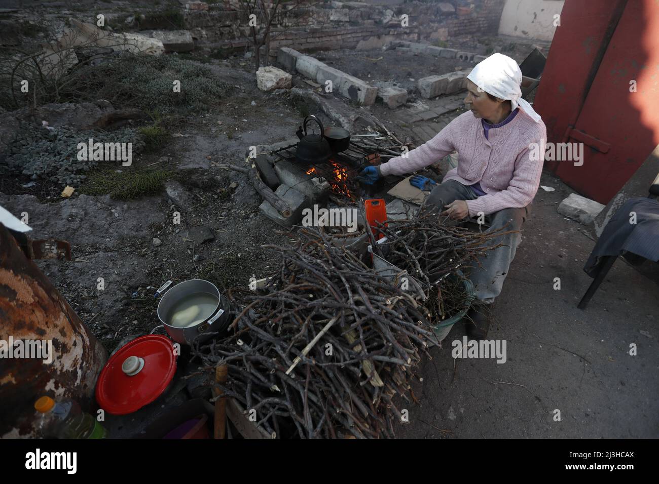 (220408) -- MARIUPOL, April 8, 2022 (Xinhua) -- A woman cooks outdoors in Mariupol, April 7, 2022. (Photo by Victor/Xinhua) Stock Photo