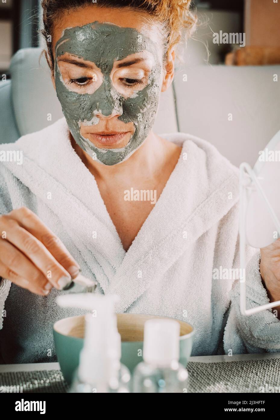 Portrait close up of adult pretty woman with cream mask anti age aging skin treatment. Female people having care and healthy beauty lifestyle. Natural products handmade Stock Photo