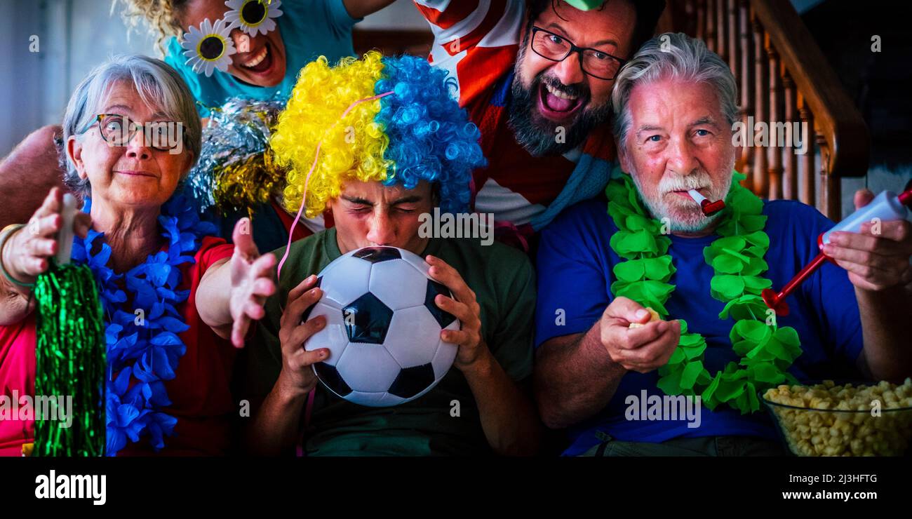 Group of football fans at home enjoy and exult for team success - world championship 2022 television concept - family watching soccer on television at home and have fun together in friendship Stock Photo