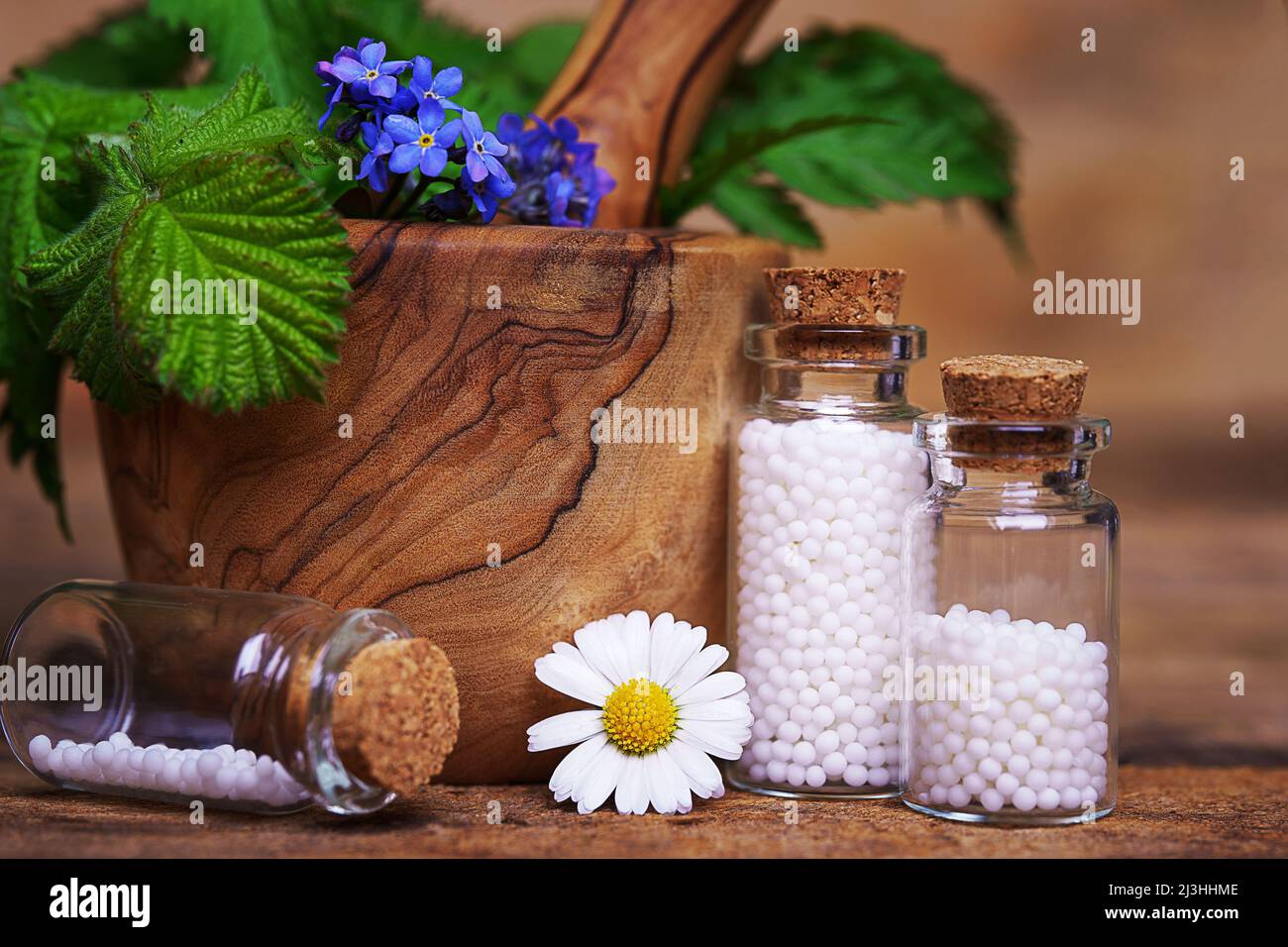 Bottles of globuli. Homeopathic remedies. Flowers and leaves in the