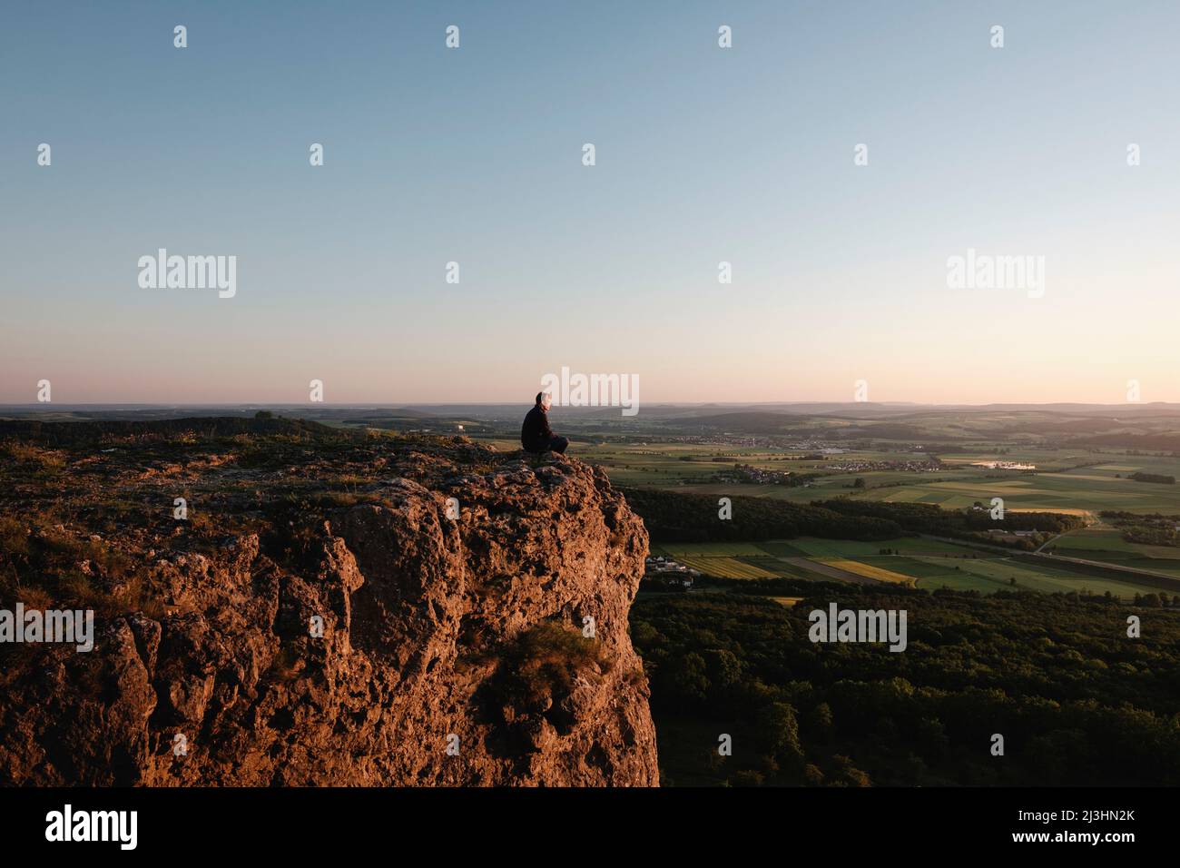 Person sitting on rocks hi-res stock photography and images - Alamy
