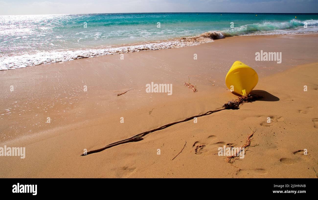 Spain, Canary Islands, Fuerteventura, south of the island, Jandia, beach, sandy beach, yellow buoy on the beach, sea glittering in the background, sea green Stock Photo
