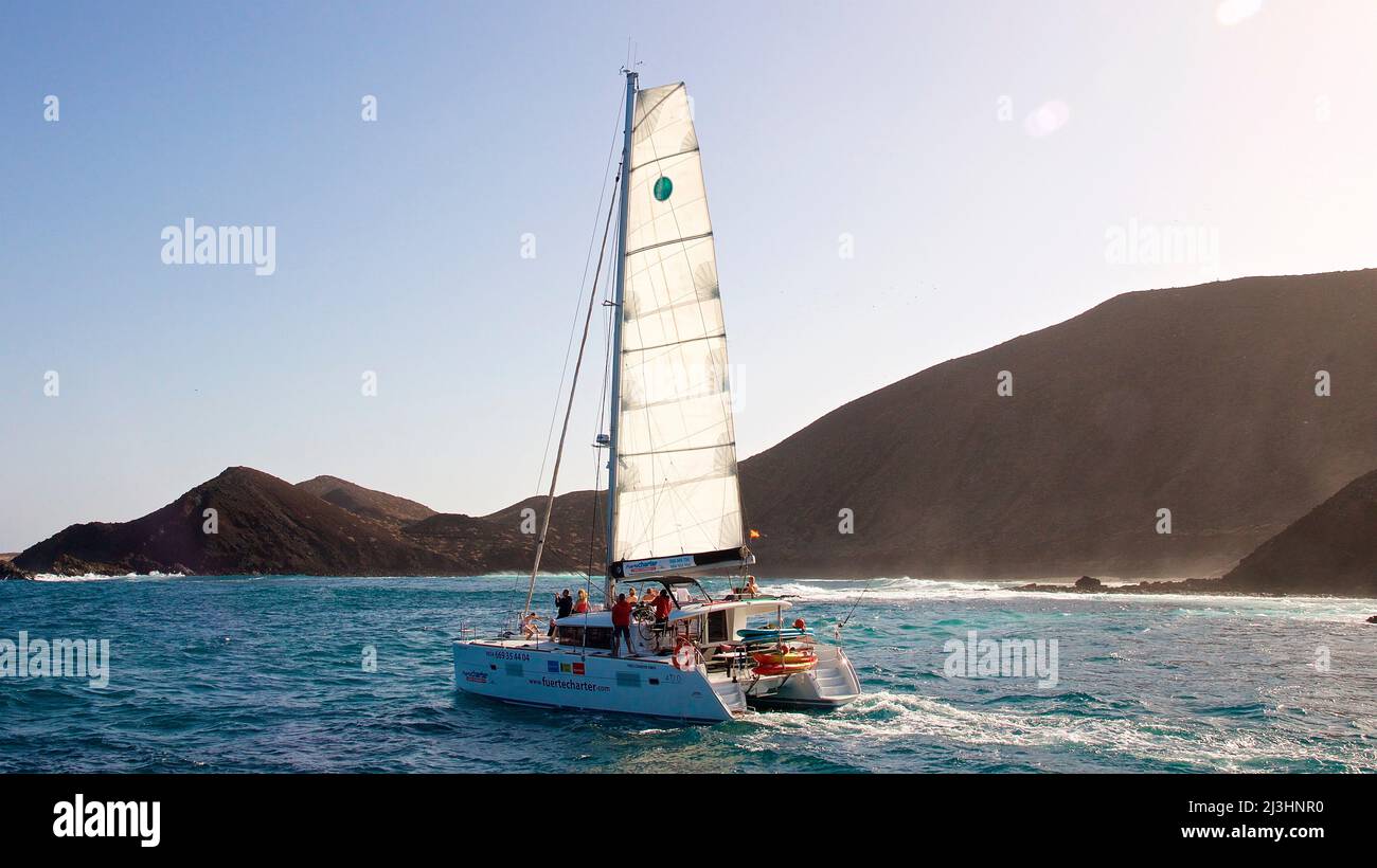 Spain, Canary Islands, Fuerteventura, sailing trip, Los Lobos island, nature reserve, sailboat, sailing from right to left, back light, Los Lobos in background Stock Photo