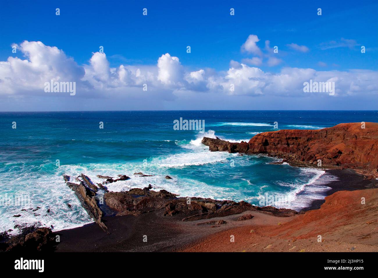 Canary Islands, Lanzarote, volcanic island, west coast, crater lake, Charco de los Clicos, lava rocks red, volcanic lake green, sky blue, clouds white, surf waves, sea blue, foaming spray Stock Photo