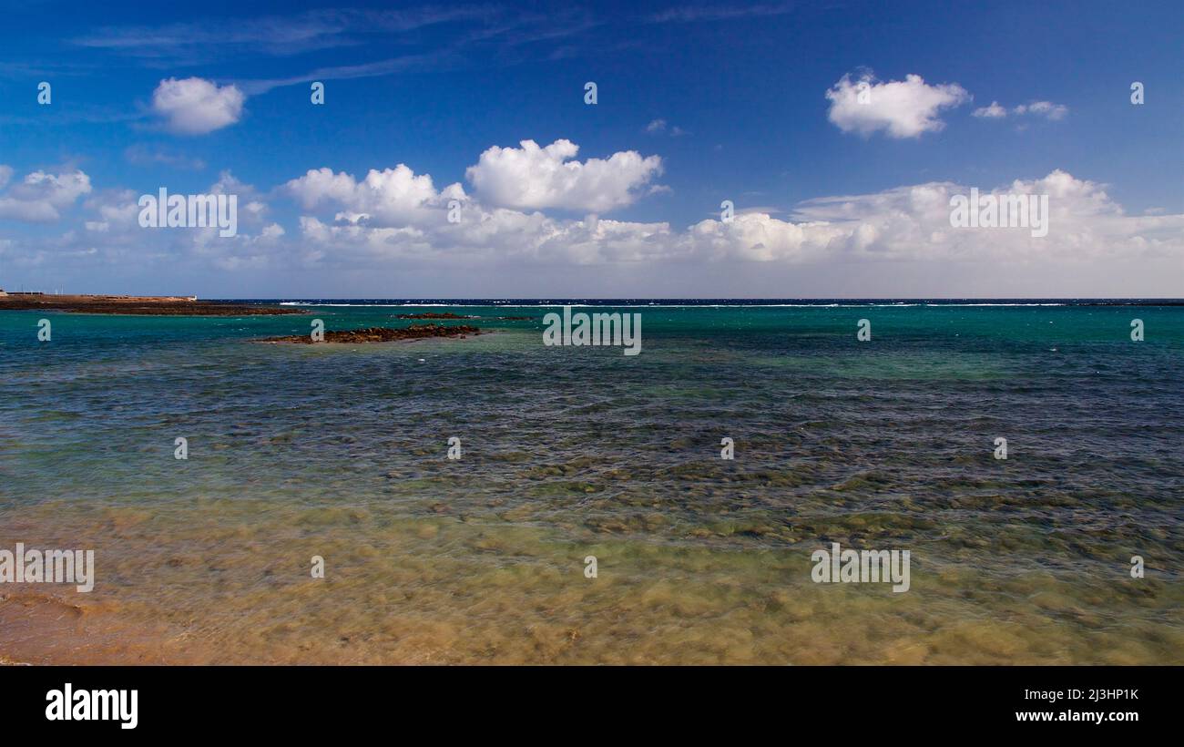 Canary Islands, Lanzarote, volcanic island, capital Arrecife, sea view, rocky reef, sea green, sky blue, clouds white Stock Photo