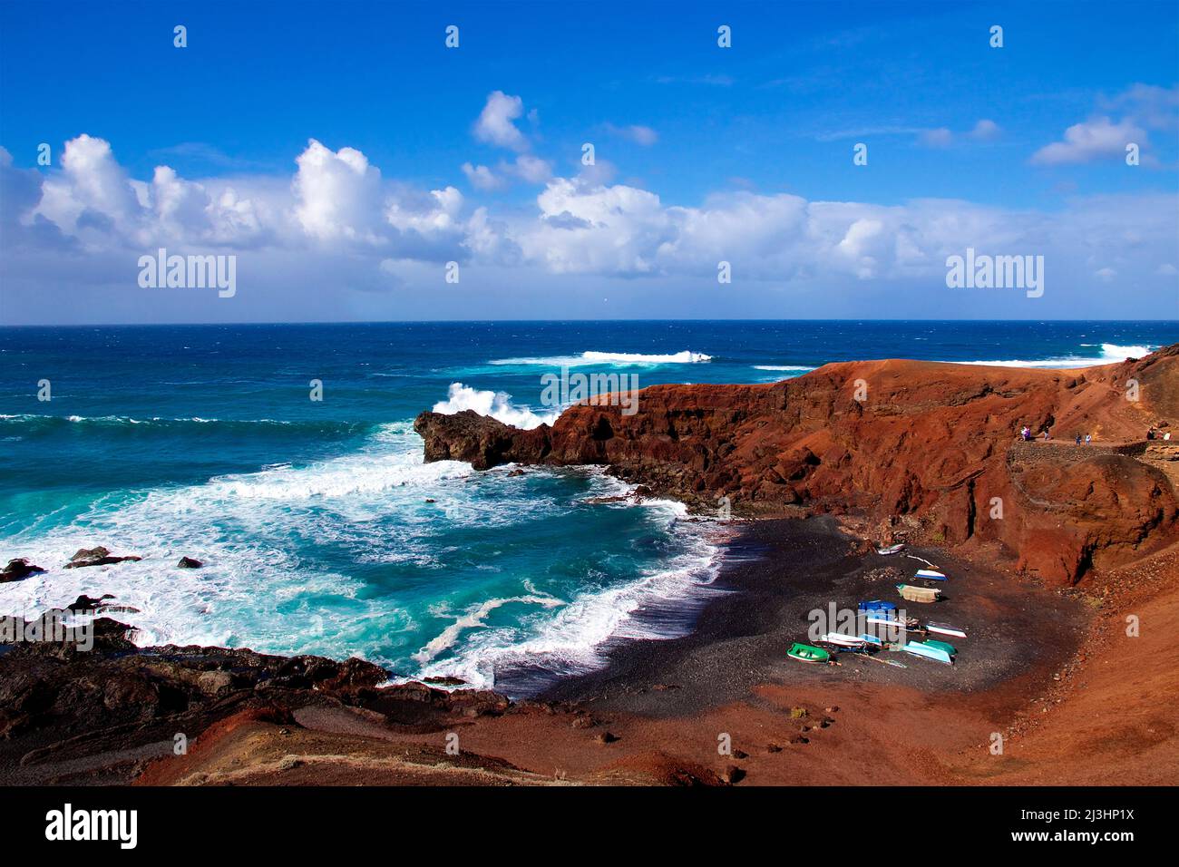 Canary Islands, Lanzarote, volcanic island, west coast, crater lake, Charco de los Clicos, lava rocks red, volcanic lake green, sky blue, clouds white, beach, parking, cars, surf, red lava bay Stock Photo