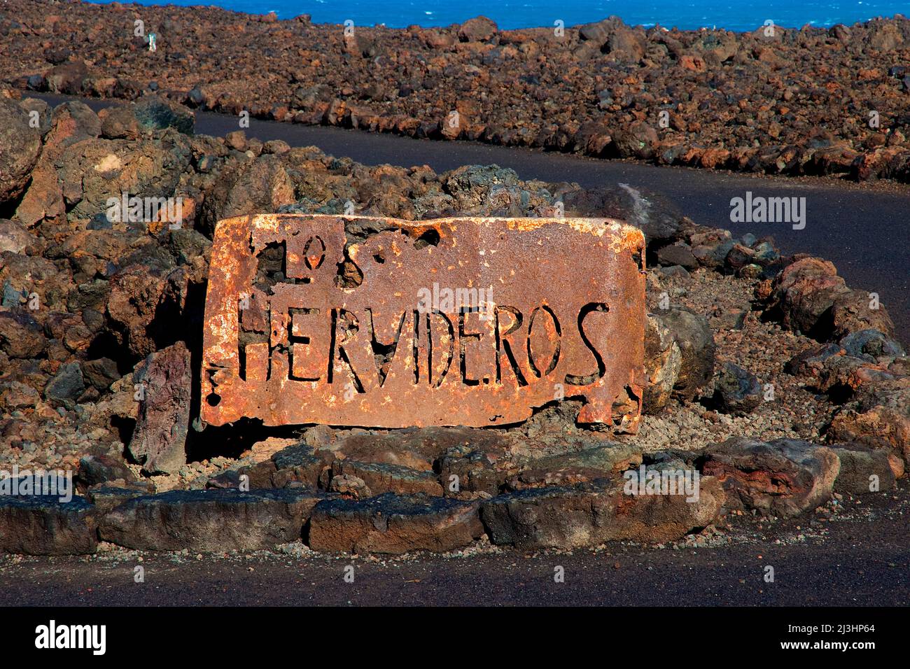Canary Islands, Lanzarote, volcanic island, southwest coast, rugged volcanic coast, strong surf, sea caves, sign with inscription 'Los Hervideros', stands in the middle of lava rock Stock Photo