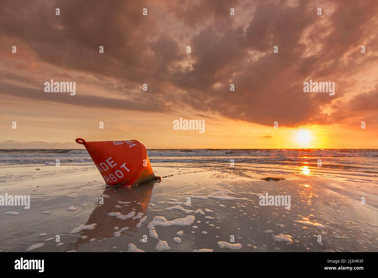 Seascape showing orange buoy on the beach at low tide and sunset over the Wadden Sea, North Frisia / Nordfriesland, Schleswig-Holstein, Germany Stock Photo