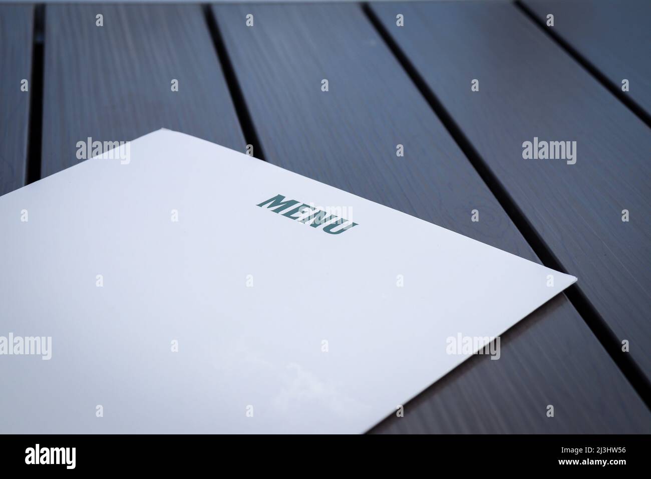 Front of a white menu, on a grey table Stock Photo