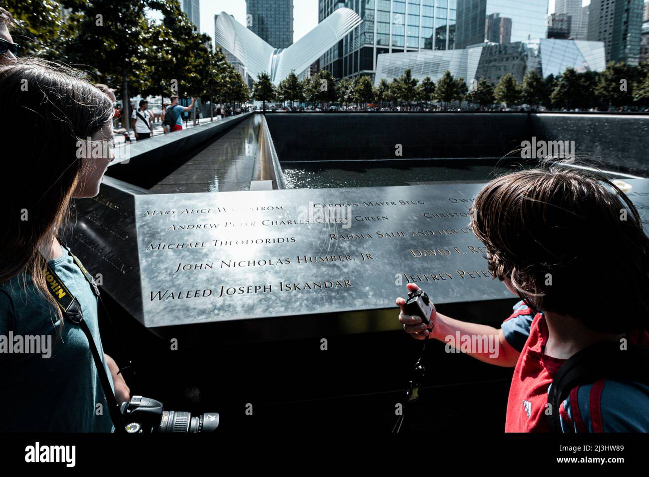 World Trade Center, New York City, NY, USA, 14 years old caucasian teenager girl and 12 years old caucasian teenager boy - both with brown hair and summer styling at the Memorial next to the new One World Trade Center in lower Manhattan Stock Photo