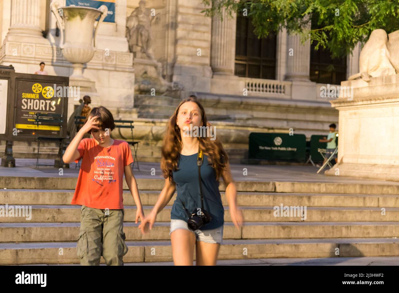 5 Av/W 41 Street, New York City, NY, USA, 14 years old caucasian teenager girl and 12 years old caucasian teenager boy - both with brown hair and summer styling in front of the New York Public Library (öffentliche Bibliothek) Stock Photo