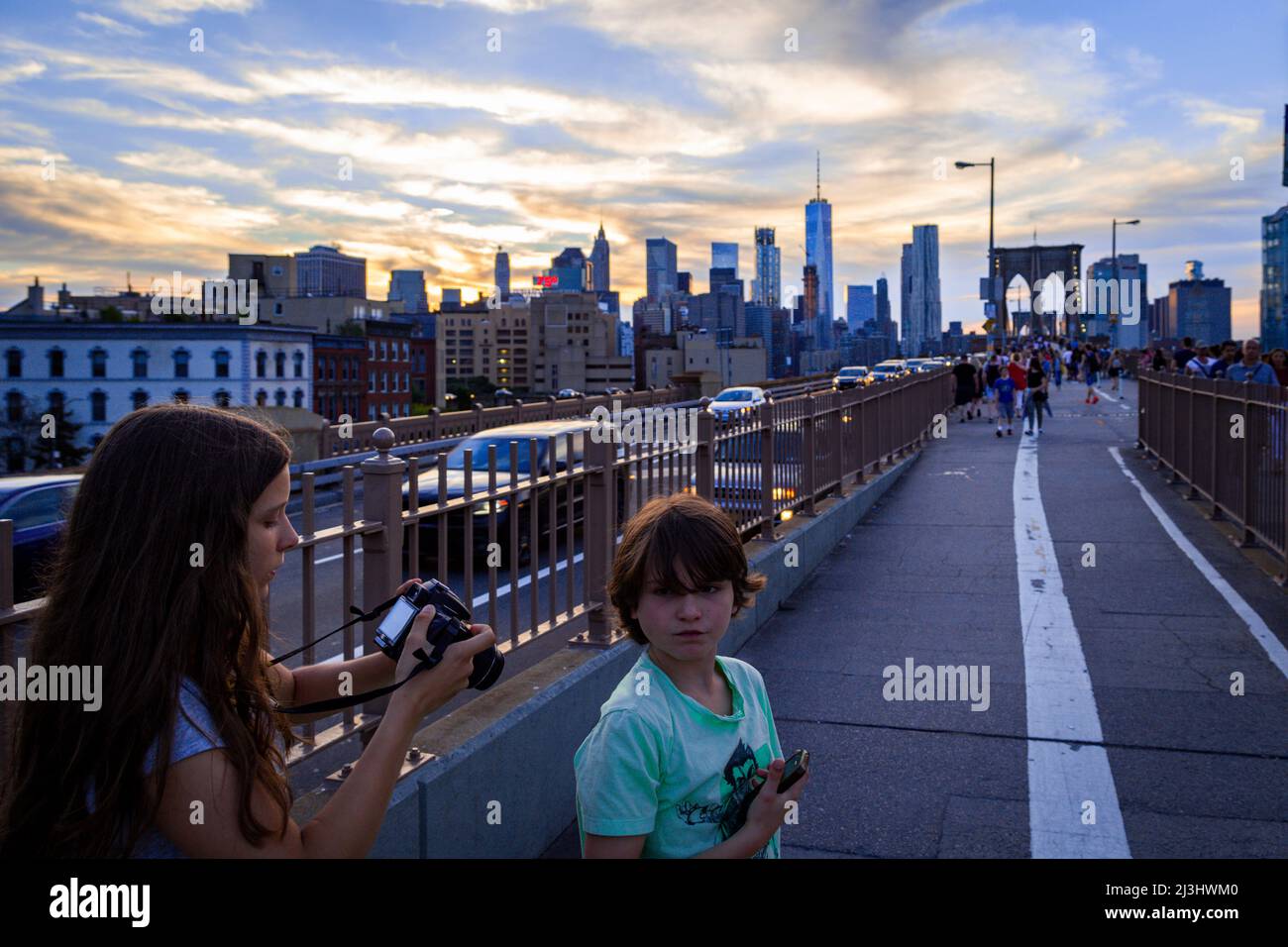 ANCHORAGE PLAZA, New York City, NY, USA, Two kids on Brooklyn Bridge over East River 14 years old caucasian teenager girl and 12 years old caucasian teenager boy - both with brown hair and summer styling on Brooklyn Bridge in the evening Stock Photo